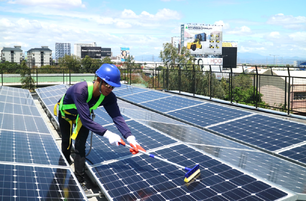 A man wiping a rooftop solar panel clean