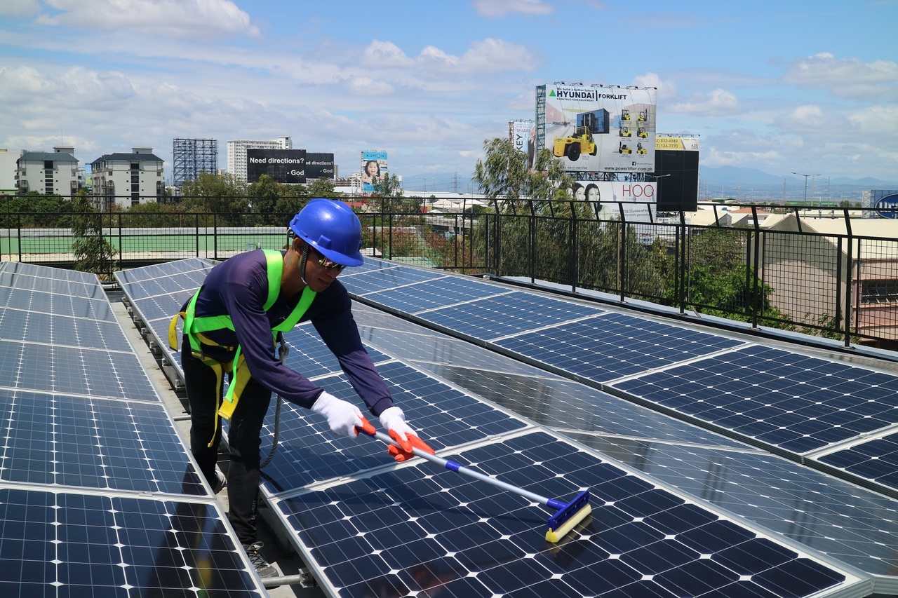 A Solaric employee cleaning solar panels