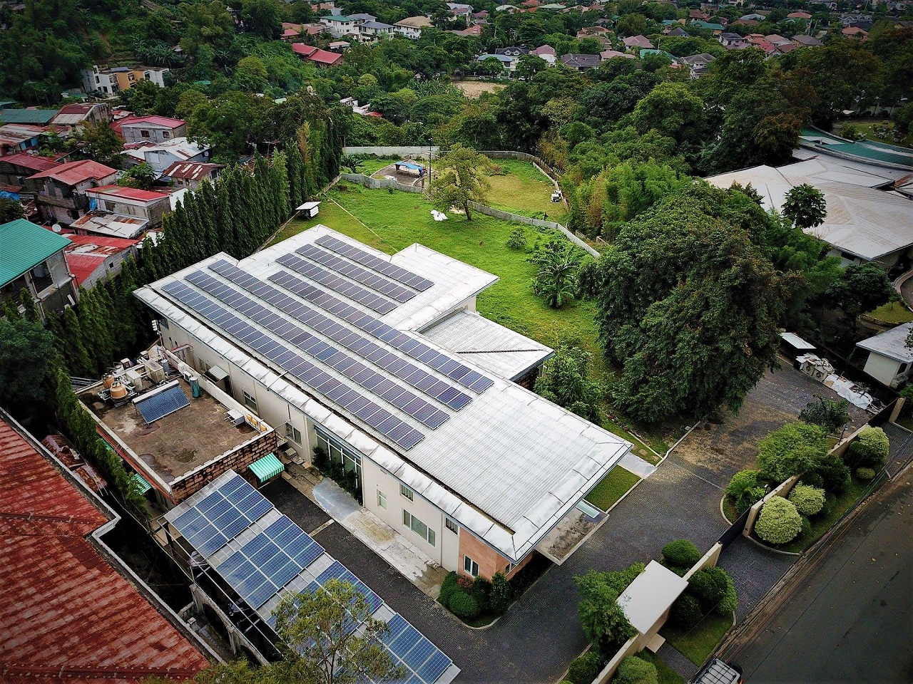 Top wide view of a white roof filled with solar panel systems