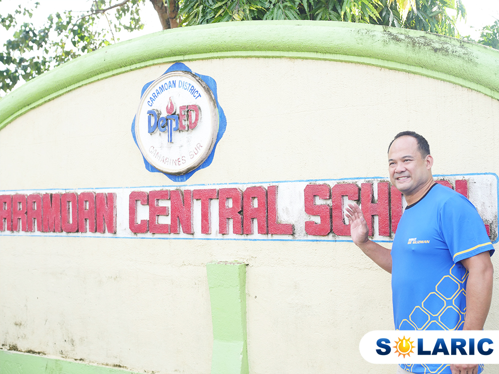 Solaric President in front of a school