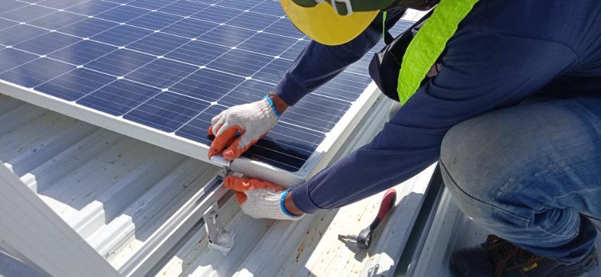 A professional solar installer installing solar grids to a roof