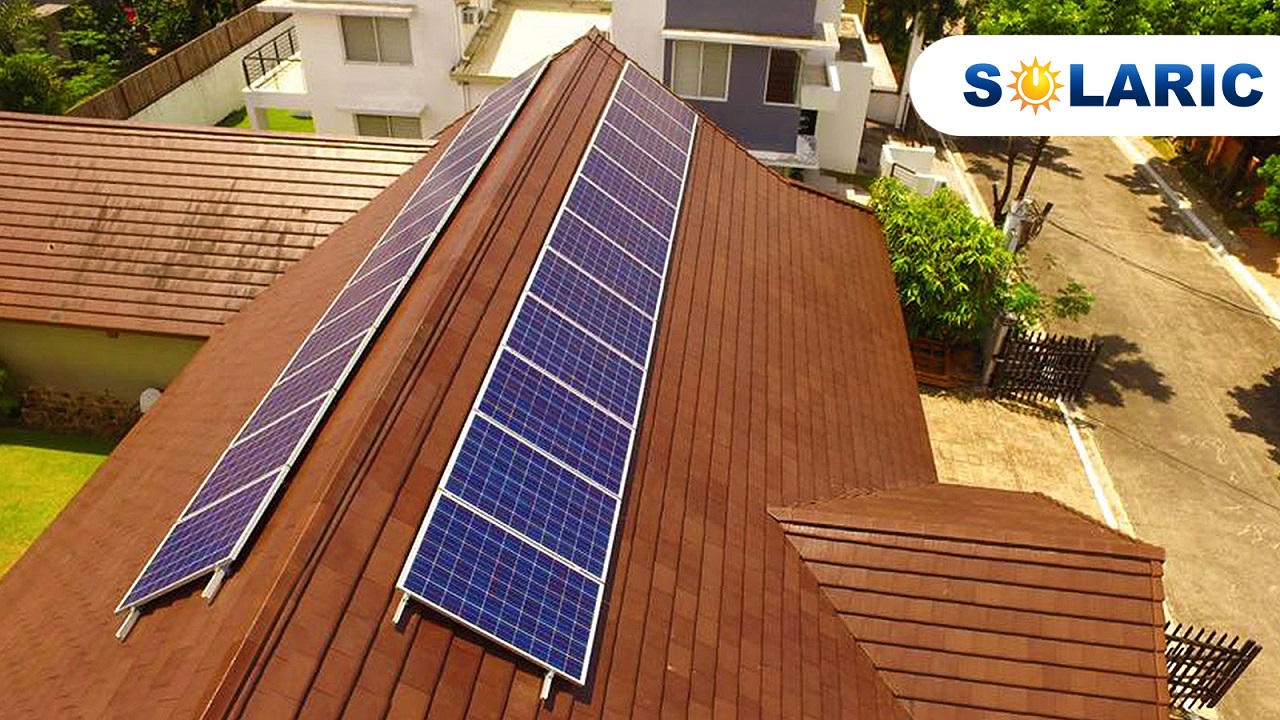 Two rows of solar panels on each side of a roof's tip