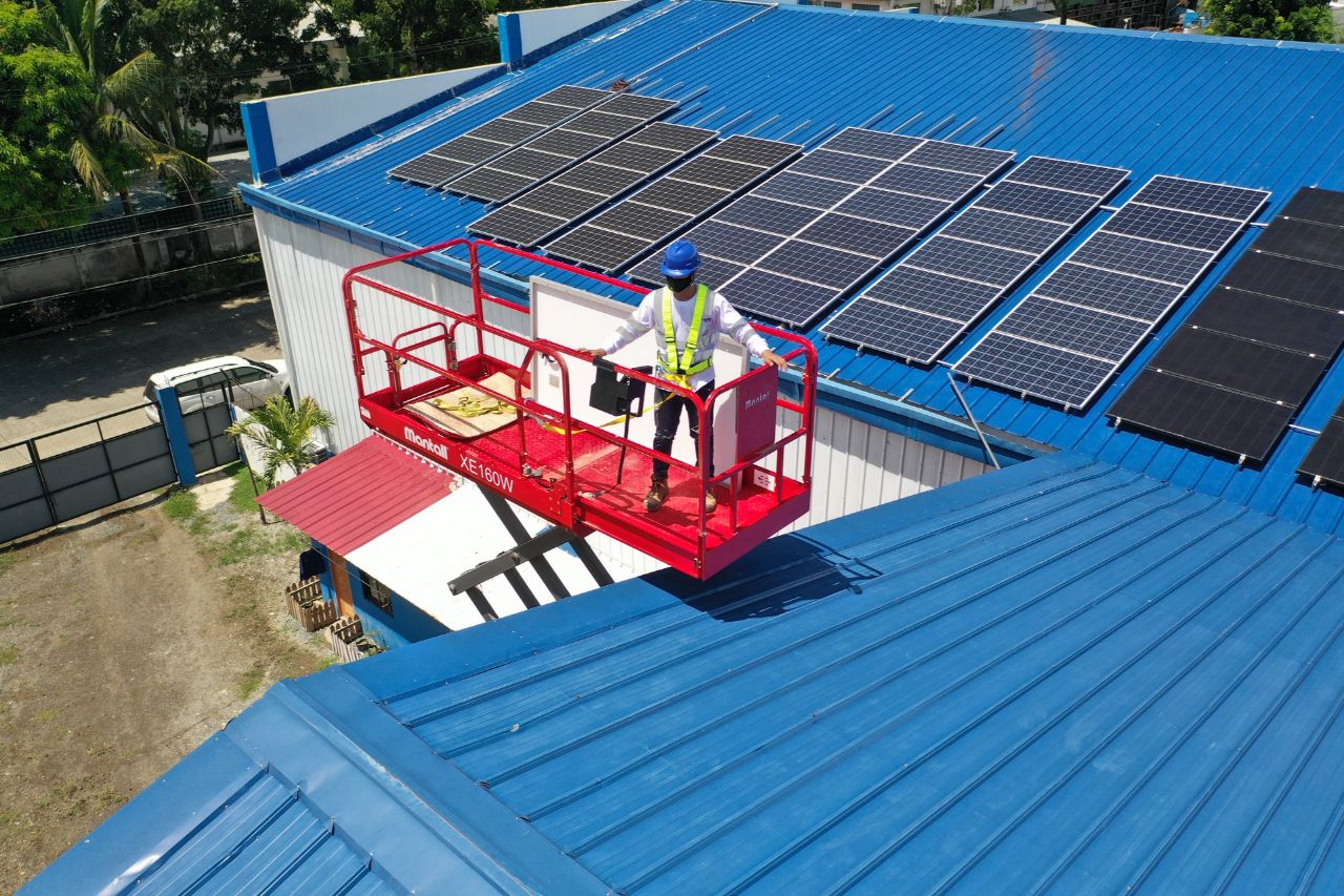 Man on a boom lift about to install solar panels