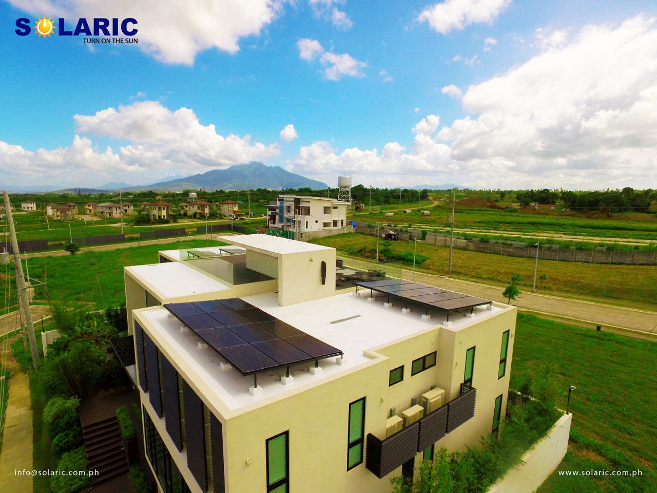 The roof of a house with solar panels overlooking its village